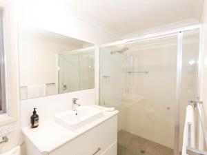 a white bathroom with a sink and a shower at Jindalee 3 34 Twynam St in Jindabyne +8 photos