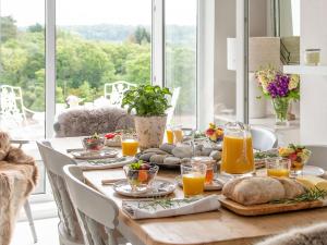 a dining room table with food and orange juice at Swn Y Wylan in Menai Bridge
