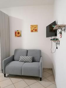 ein Wohnzimmer mit einem Sofa und einem TV in der Unterkunft LUX IUN Q2026 in Lanusei