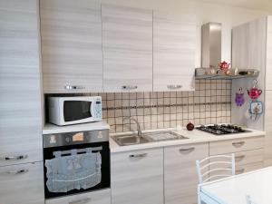 a kitchen with a microwave and a stove top oven at LUX IUN Q2026 in Lanusei