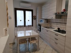 a kitchen with a table and chairs in a kitchen at LUX IUN Q2026 in Lanusei
