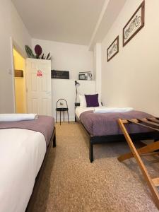 een kamer met drie bedden en een tafel erin bij Central Located Two Bedroom Suite in Bristol