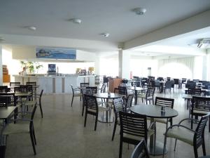 a dining room with tables and chairs in a restaurant at Corfu Sea Gardens Hotel in Kavos