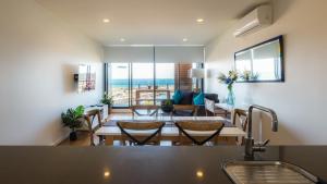 uma sala de jantar e sala de estar com mesa e cadeiras em Waterfront Apartments Marinaquays -Apt 221 and Apt 234 em Werribee South