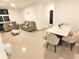 a living room with a white table and chairs at Como en casa, familiar, fresco y relax. in Santa Cruz de la Sierra