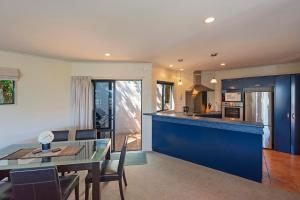 a kitchen and dining room with a blue counter top at On The Rocks in Nelson