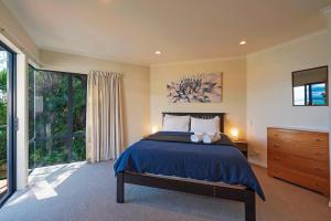 a bedroom with a bed and a large window at On The Rocks in Nelson