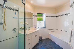 a bathroom with a tub and a sink and a shower at On The Rocks in Nelson +27 photos