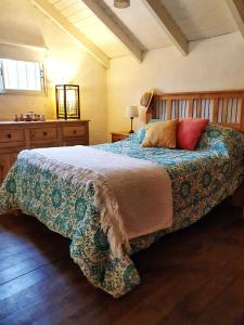 1 dormitorio con 1 cama grande y cabecero de madera en Cabaña Josefina en Los Reartes