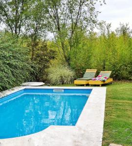 una piscina en un patio con 2 tumbonas en Cabaña Josefina en Los Reartes