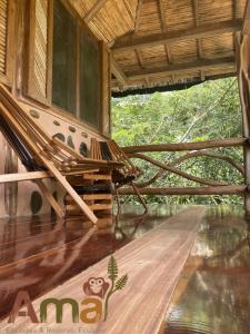 a porch with a hammock in a bamboo house at Ama Ecolodge in Puerto Misahuallí