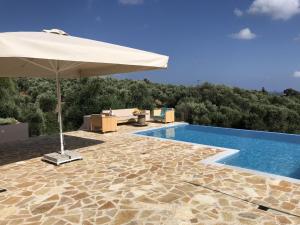 KamáriaにあるLuxurious Villa in Kamaria Peloponnese with Swimming Poolのスイミングプールの隣に傘付きのスイミングプール