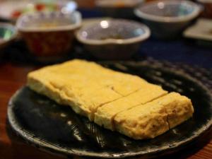 een zwarte plaat met wat eten op tafel bij Oyado Ichifuji in Nikko