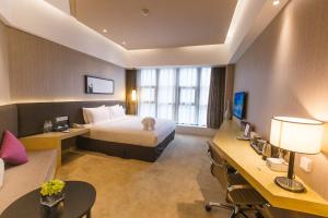 um quarto de hotel com uma cama e uma secretária em Skytel Hotel Chengdu-City Center em Chengdu