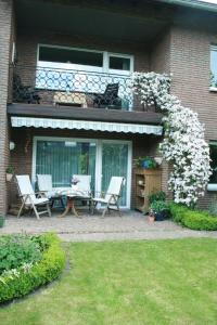 ein Haus mit einer Terrasse mit einem Tisch und Stühlen in der Unterkunft Ferienwohnung Illerhues in Ascheberg