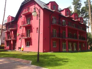 a red building with a street light in front of it at Villa Tropico śniadanie i obiadokolacja in Pobierowo