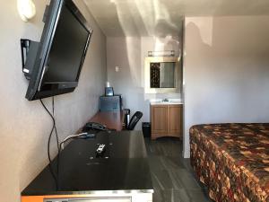 a hotel room with a television and a bed at Budget Inn & Suites in Amarillo