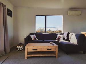 a living room with a blue couch and a coffee table at A Place in the Paddock in Matamata