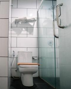 uma casa de banho com um WC e uma cabina de duche em vidro. em Kalya Hotel Bandung Dago em Bandung