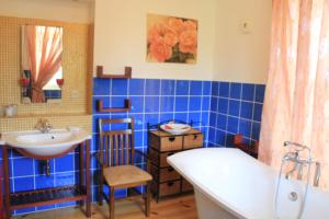 ein blau gefliestes Bad mit einem Waschbecken und einer Badewanne in der Unterkunft Villa Kursa in Sighnaghi