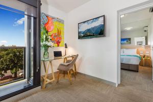 本迪戈Mercure Bendigo Schaller的客房设有书桌、床和窗户。