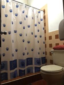 a bathroom with a blue and white shower curtain with a toilet at Dionisio Inn in Antigua Guatemala