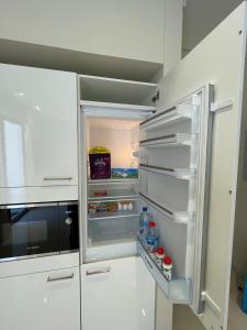 an empty refrigerator with its door open in a kitchen at Mokango Apartment Hawana Salalah in Salalah