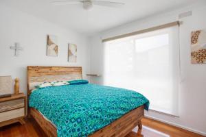 Beach Days Family Escape, Dromana في درومانا: غرفة نوم مع سرير مع لحاف أخضر