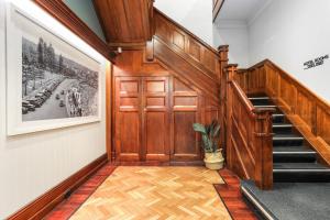 a hallway with a wooden door and stairs with a potted plant at Coogee Bay Hotel in Sydney