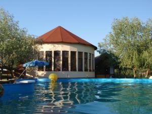 a swimming pool with a building in the background at Pension Prodelta in Uzlina