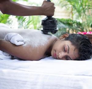 Kobieta leżąca na ręczniku w gabinecie masażu w obiekcie Healthville by WB Resorts w mieście Chandaka