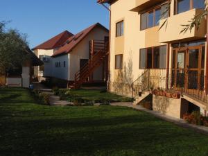 a house with a grass yard in front of it at Pension Prodelta in Uzlina