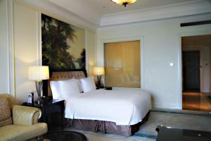 a bedroom with a large white bed and a couch at Crowne Plaza Ocean Spring Resort, an IHG Hotel in Jimo