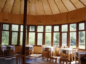 a large room with tables and chairs and windows at Pension Prodelta in Uzlina