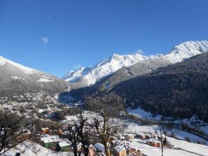 a town in the snow with mountains in the background at B&B Villa Dalegno in Temù