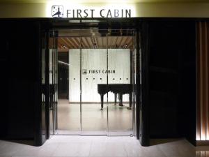 an open glass door with a piano in a building at First Cabin Kansai Airport in Izumi-Sano