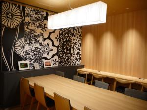 a dining room with a long table and chairs at First Cabin Kansai Airport in Izumi-Sano