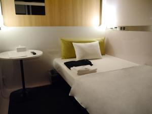 a hotel room with a bed and a small table at First Cabin Kansai Airport in Izumi-Sano