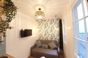 uma sala de estar com um sofá e um lustre em Home Sweet Home Pigalle Montmartre Jungle em Paris