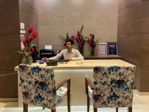 a man sitting at a desk in an office at Hotel Park Plaza in Panaji