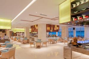 une salle à manger avec des tables et des chaises dans un restaurant dans l'établissement Crowne Plaza Dalian Sports Center, an IHG Hotel, à Dalian