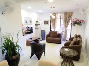 a living room with a couch and a table at Vitatree Cottage in Kuah