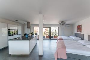 a kitchen and a bedroom with two beds and a counter at VV hotel & apartments in Brno
