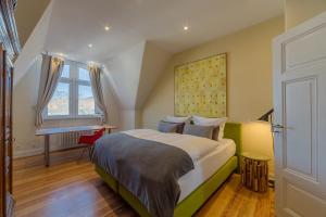 a bedroom with a large bed and a desk at Zweite Heimat Heidelberg in Heidelberg