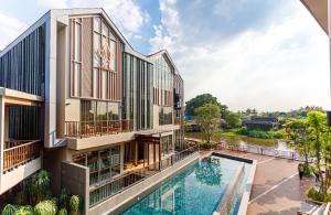 an external view of a building with a swimming pool at W1Bangkoknoi Hotel in Nonthaburi