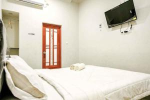 a hospital room with a bed and a flat screen tv at Rudi Rooms near Stasiun Cikarang Mitra RedDoorz in Jakarta