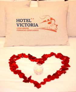 a heart made out of red roses next to a pillow at Hotel Victoria Lyon Perrache Confluence in Lyon