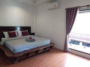Sunflora Resort Chumphon في شومفون: غرفة نوم عليها سرير محشوة