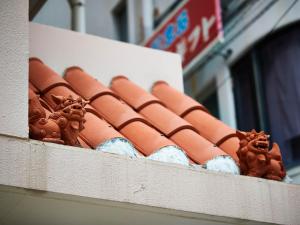a roof of a building with red tiles on it at Terrace Resort Shintoshin in Naha