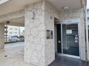an entrance to a building with a glass door at Terrace Resort Shintoshin in Naha